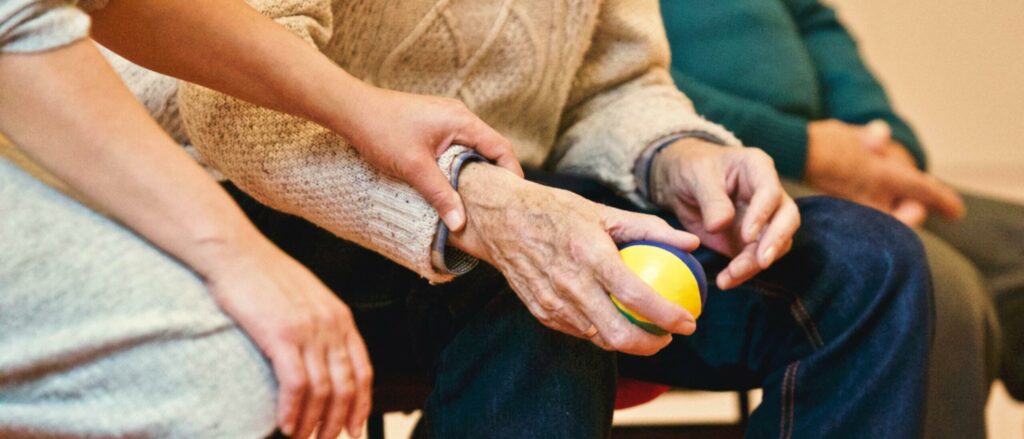 A hand holding a old man's hand